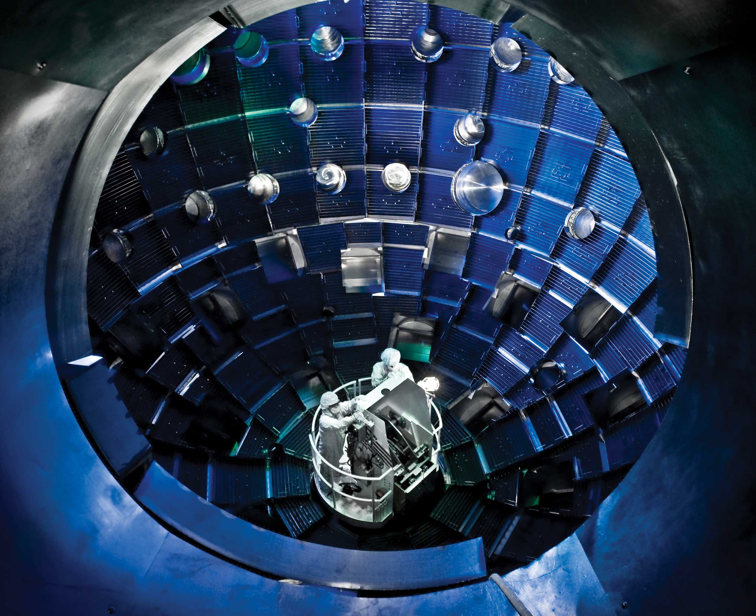 Workers performing service on a manlift in a nuclear environment at NIF Target Chamber