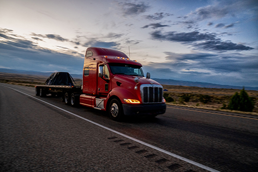 Semi pulling flat bed trailer