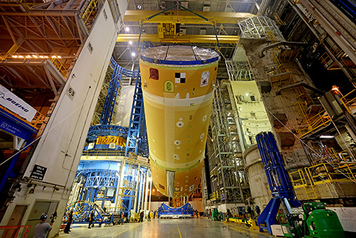 Specialty crane with extra safety and monitoring lifting the Artemis SLS space launch vehicle during manufacturing