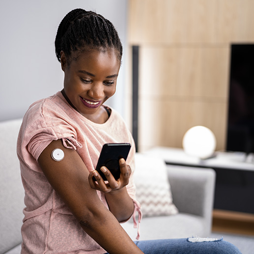 Young woman testing glucose with wearable diabetes device