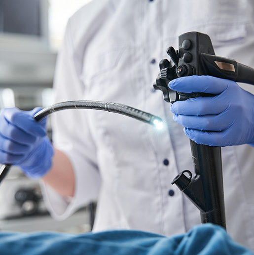 Healthcare professional holding endoscope during gastroscopy.