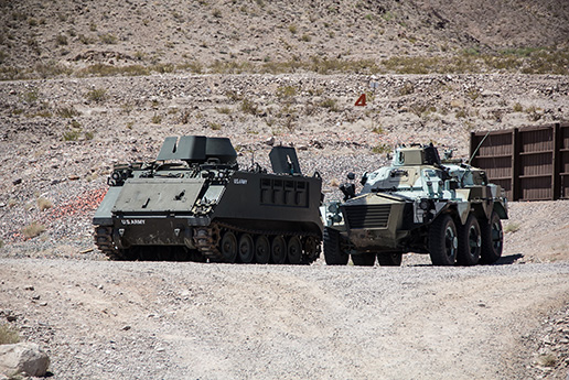 Two tanks on a sandy, rocky landscape